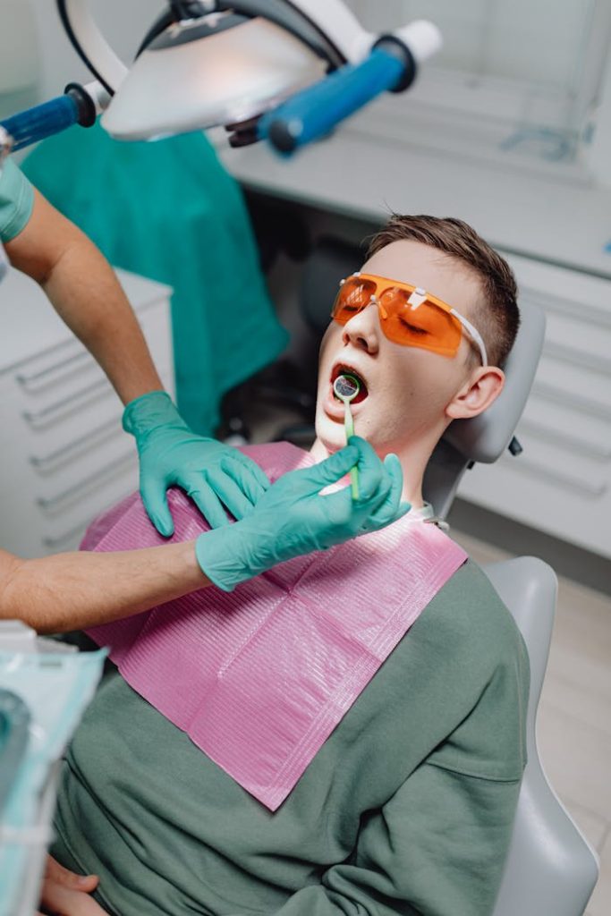 A young adult receives dental treatment at a modern clinic, showcasing oral hygiene practices.