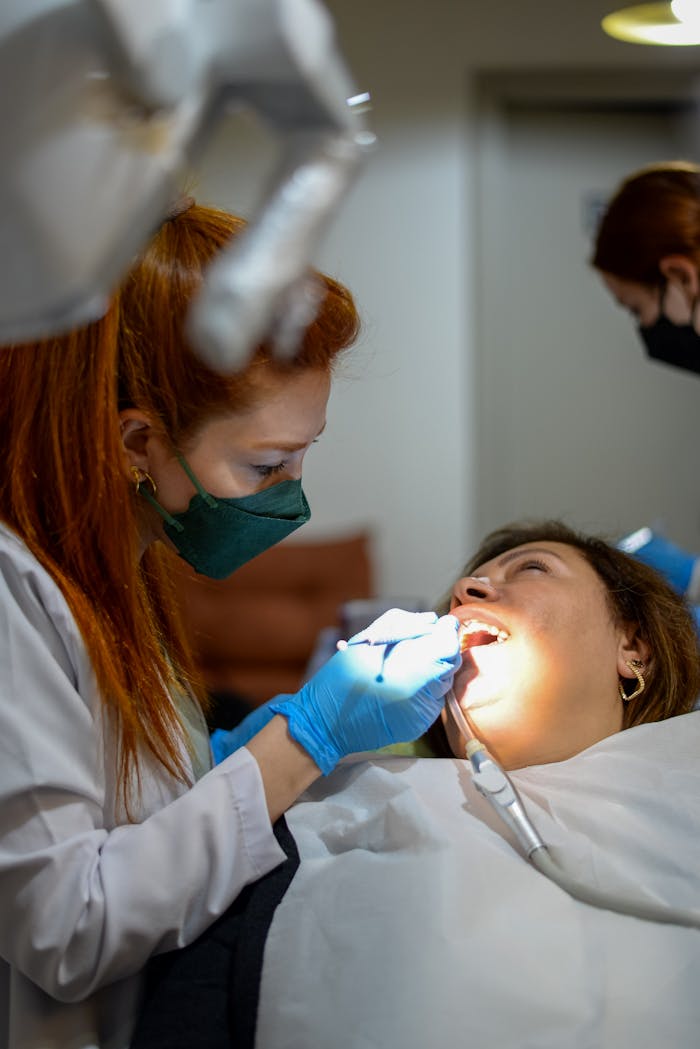 A female dentist examining a patients teeth with precision and care.